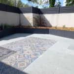 Terrasse en béton avec carreaux de ciment décoratifs à Vertou par Léauté Paysage